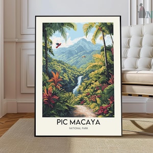 May include: A framed art print of Pic Macaya National Park. The artwork depicts a lush tropical landscape with a waterfall, mountains, and vibrant flora. The print includes the text "PIC MACAYA NATIONAL PARK" at the bottom.