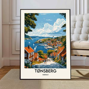 May include: A framed art print featuring a colorful illustration of Tønsberg, Norway. The artwork depicts a coastal town with red-roofed buildings, a lighthouse, and sailboats on the water under a blue sky with fluffy clouds. The text "Tønsberg Norway" is at the bottom.