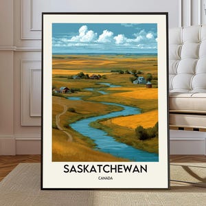May include: A framed landscape print of Saskatchewan, Canada. The artwork depicts a winding river flowing through golden fields under a blue sky with fluffy white clouds. The print has a black frame and the text "SASKATCHEWAN CANADA" at the bottom.