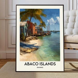 May include: Framed art print of the Abaco Islands in the Bahamas. The artwork shows colourful buildings on a beach with palm trees, boats, and clear turquoise water under a blue sky. The text "ABACO ISLANDS BAHAMAS" is at the bottom.