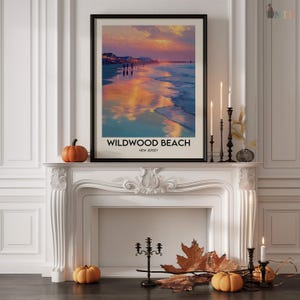 K&ouml;nnte beinhalten: Ein gerahmter Druck von Wildwood Beach, New Jersey, mit einem Sonnenuntergang &uuml;ber dem Meer. Das Kunstwerk wird &uuml;ber einem wei&szlig;en Kamin ausgestellt, der mit K&uuml;rbissen, Kerzen und Herbstlaub dekoriert ist. Der Druck hat einen schwarzen Rahmen.