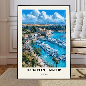 May include: A framed vertical art print featuring a vibrant coastal scene of Dana Point Harbor, California. The image displays numerous white boats docked in bright blue water, surrounded by palm trees, buildings, and a sky with white clouds.