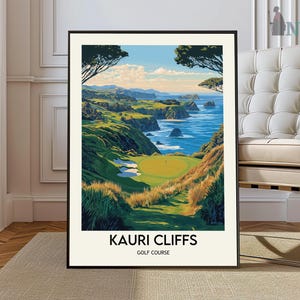 May include: A framed art print of the Kauri Cliffs Golf Course. The image depicts a vibrant golf course with green fairways, cliffs, and the ocean. The text "KAURI CLIFFS GOLF COURSE" is printed at the bottom of the image.