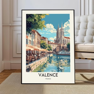 Puede incluir: Una impresión artística enmarcada que presenta una vista panorámica de Valence, Francia. La obra de arte representa una escena fluvial con edificios, cafés y una catedral bajo un cielo azul. La impresión incluye el texto "VALENCE FRANCE".