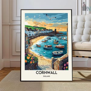 May include: A colorful painting of a harbor scene in Cornwall, England. The painting depicts a row of colorful buildings along the waterfront, with boats docked in the harbor. The sky is a bright blue with white clouds, and the water is a deep blue. The painting is framed in a black frame.