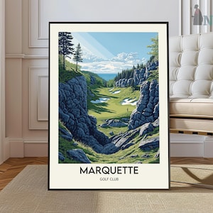 May include: A framed print of a golf course scene. The artwork depicts a green golf course nestled between rocky cliffs, with a blue sky and ocean in the background. The text "MARQUETTE GOLF CLUB" is at the bottom.