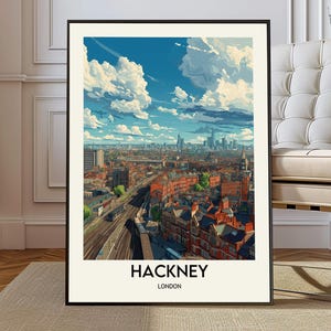 May include: A framed art print featuring a stylized cityscape of Hackney, London, under a bright blue sky with fluffy white clouds. The print has a black frame and includes the text "HACKNEY LONDON" at the bottom.