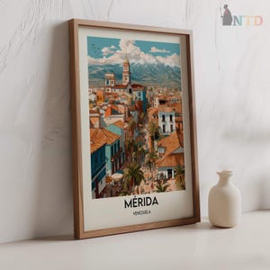 K&ouml;nnte beinhalten: Ein gerahmter Kunstdruck von M&eacute;rida, Venezuela, mit einer farbenfrohen Stadtlandschaft mit Geb&auml;uden, Palmen und Bergen im Hintergrund. Der Druck befindet sich in einem Holzrahmen und tr&auml;gt unten den Namen der Stadt.