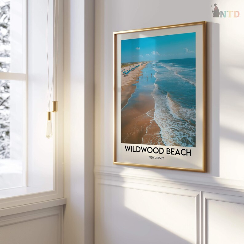 May include: A framed print of Wildwood Beach, New Jersey, showing an aerial view of the shoreline. The image displays the ocean's blue waters, sandy beach, and a clear sky. The print is in a gold frame.
