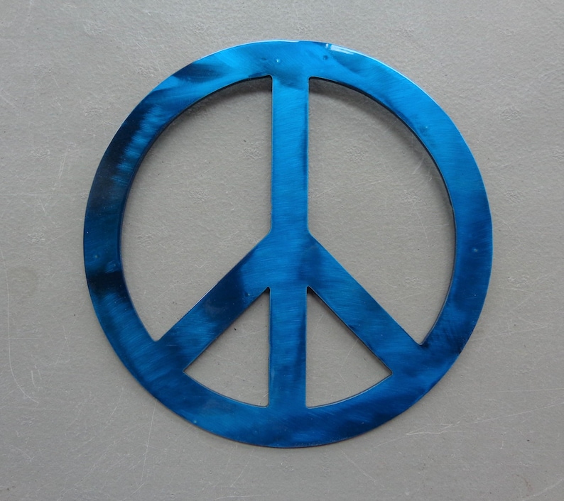 May include: A blue peace sign with a brushed metal finish. The peace symbol is a circle with a vertical line and two diagonal lines inside. The symbol is centered on a gray background.