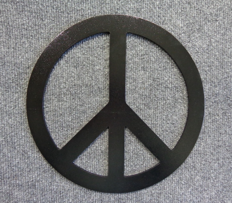 May include: A black peace sign, a symbol of peace and non-violence, is centered against a gray textured background. The peace symbol is a circle with three downward-pointing lines.