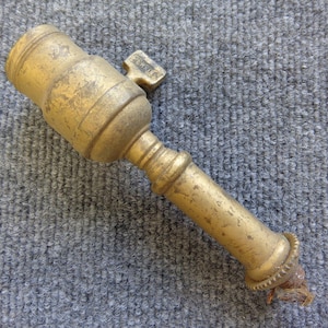 May include: A vintage brass lamp socket with a key-shaped switch. The socket has a cylindrical body with a textured surface and a slightly tarnished finish. The key is stamped with the word "PAT. OFF."