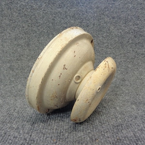 May include: Off-white, antique-style door knob with a distressed finish. The knob has a rounded, cup-like base and a circular handle. The metal shows signs of rust, giving it a vintage appearance. Ideal for restoration projects.