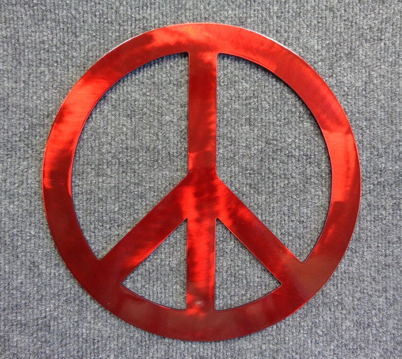 May include: A red peace sign made of metal. The peace symbol is a circle with a vertical line through the center and two diagonal lines extending downward. The sign is a bright, shiny red color.