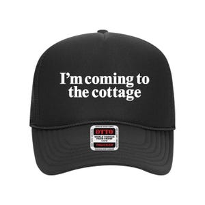 May include: Black trucker hat with the text "I'm coming to the cottage" in white. The hat has a mesh back and a curved brim. The hat also has a small tag that says "OTTO" and "Trucker".