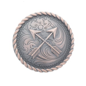 以下が含まれることがあります： ロープ状の縁取りが施された銀色と銅色の金属製のベルトバックル。バックルには、中央に交差した2本の矢印が描かれた花柄のデザインが施されています。