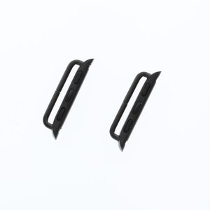 May include: Two black metal watch band adapters. The adapters are designed to connect a watch band to a watch.