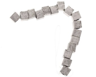 May include: A curved line of small, grey, square-shaped tiles.