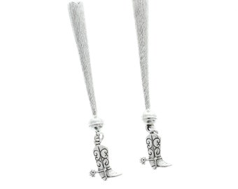May include: A pair of silver earrings with a dangling boot charm. The boots have a detailed design and a spur.