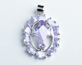 May include: A silver pendant with a clear crystal cross surrounded by a halo of smaller purple crystals.