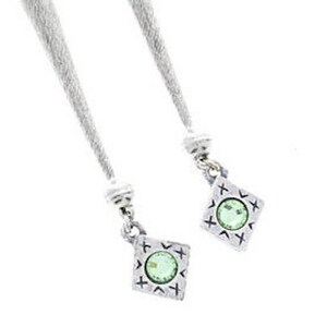 Puede incluir: Dos colgantes de plata con una piedra preciosa verde en el centro de cada uno. Los colgantes tienen forma de diamante con un patr&oacute;n decorativo alrededor de los bordes.
