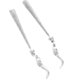 Könnte beinhalten: Ein Paar silberne Ohrringe mit einer langen, strukturierten Kette und einem kleinen, gebogenen Horn-Anhänger am Ende.