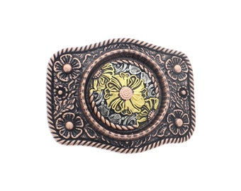 May include: A silver and gold belt buckle with a floral design. The buckle is square shaped with rounded corners and has a rope-like border. The centre of the buckle features a large flower with a yellow centre and pink accents.