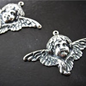 Puede incluir: Dos encantos de querub&iacute;n de plata con alas y una cara detallada. Los encantos tienen un bucle en la parte superior para sujetarlos a joyas u otras manualidades.