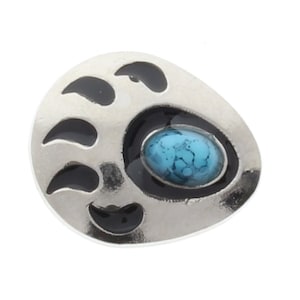 Pode incluir: Encanto de pata de urso de prata com uma pedra turquesa no centro.