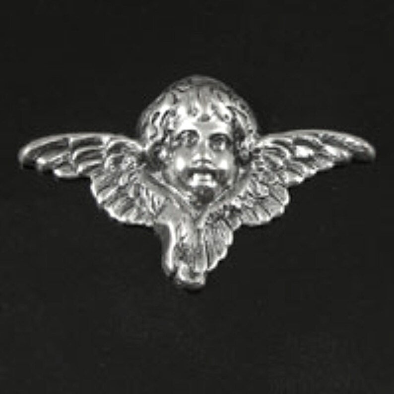 Puede incluir: Encanto de querub&iacute;n de plata con las alas extendidas. El querub&iacute;n tiene una cara redonda con una expresi&oacute;n dulce.