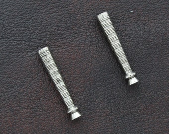 Op de afbeelding: Twee zilveren metalen rookpijpen met een textuurontwerp.
