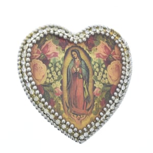 May include: A heart-shaped trinket box with a silver-colored border and a colorful image of the Virgin Mary surrounded by roses.