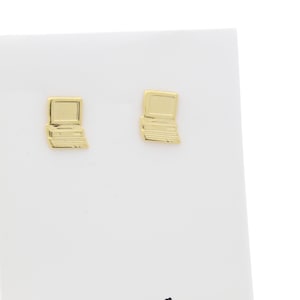 May include: A pair of gold-toned earrings shaped like a vintage laptop computer.