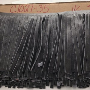 May include: Black leather fringe trim with a label that reads "C1027-35".