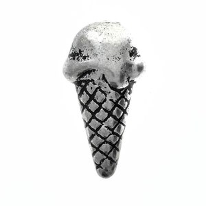 Könnte beinhalten: Ein silberner Eiswaffel-Anhänger mit detaillierter Waffelstruktur.