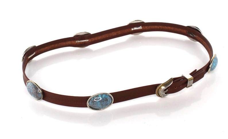 May include: A thin brown leather belt featuring multiple oval-shaped blue and brown marbled stone inlays set in silver-toned metal frames. The belt includes a silver-toned metal buckle with intricate engraved detailing and a matching metal keeper.