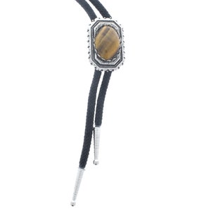 May include: A black bolo tie with a silver and tiger's eye stone bolo tie slide.