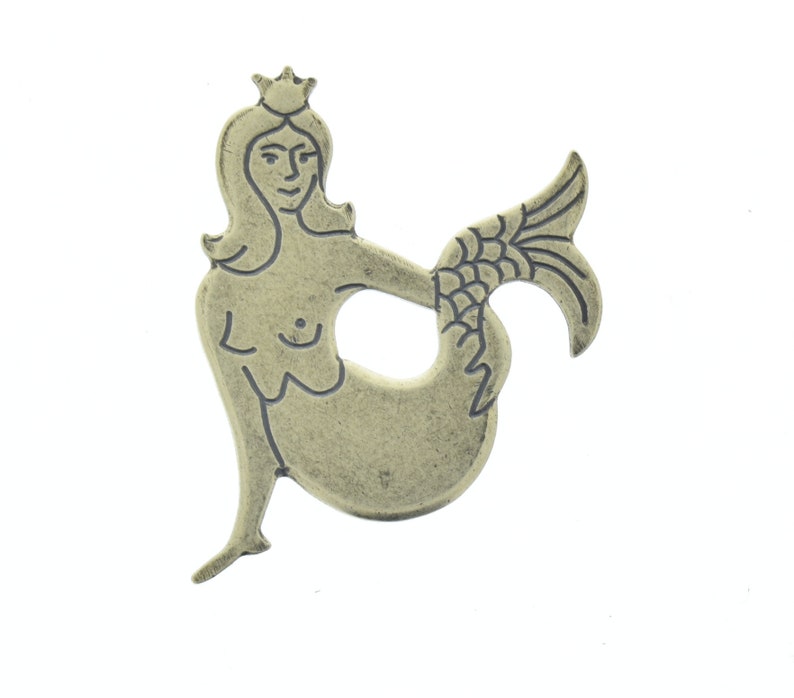 May include: A silver-toned mermaid charm with a crown, outlined in black. The mermaid is depicted with a flowing tail and a crown on her head.