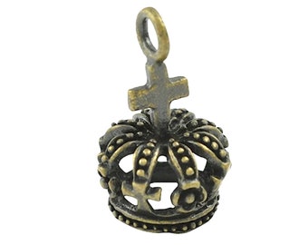 May include: A small, antique gold-toned crown charm with a cross on top. The crown has a detailed design with small dots and a loop at the top for attaching to a necklace or bracelet.
