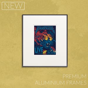 Op de afbeelding: Ingelijste concertposter voor Killswitch Engage's live optreden in 2019, met een levendige illustratie van een brullend beest in rood, blauw en geel. De poster is geplaatst in een witte passe-partout en een zwart aluminium frame, met het woord "NEW" linksboven.