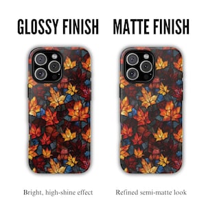 May include: Two phone cases with a fall leaf design. One case has a glossy finish, the other a matte finish. The cases feature a colorful pattern of red, orange, and yellow leaves on a dark background. The text reads "Glossy Finish" and "Matte Finish".