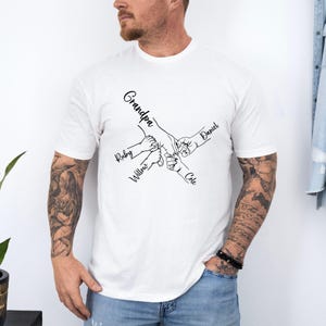 May include: White t-shirt with a black line drawing of five hands holding each other. The text "Grandpa", "Ruby", "Willow", "Cole", and "Daniel" are written next to each hand.