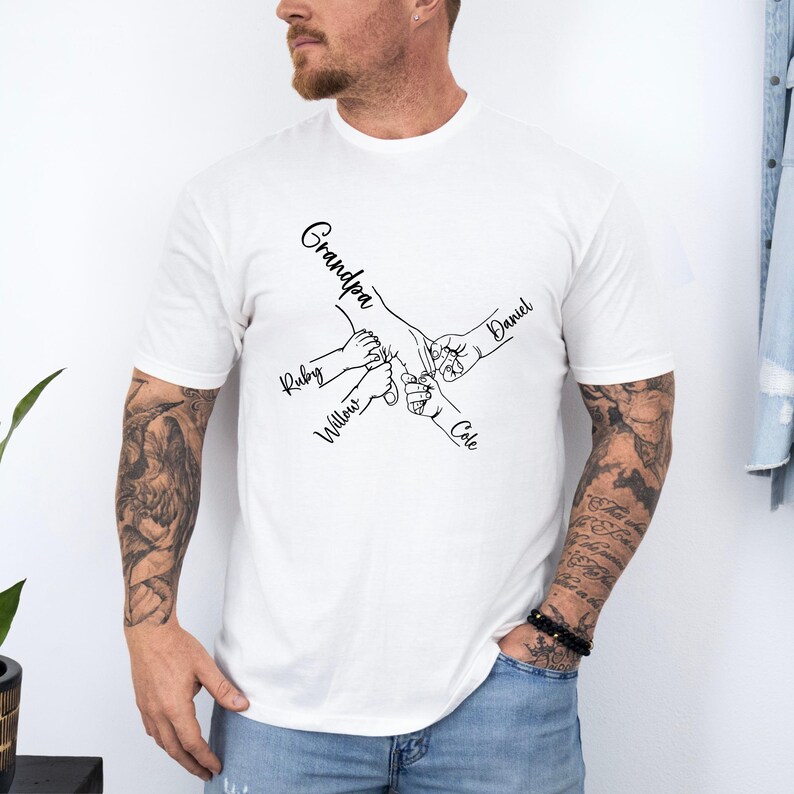 May include: White t-shirt with a black line drawing of five hands holding each other. The text "Grandpa", "Ruby", "Willow", "Cole", and "Daniel" are written next to each hand.
