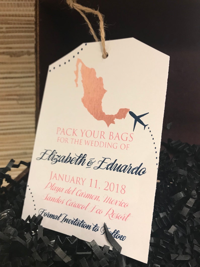 May include: A white luggage tag with a brown outline and a pink and blue design. It says "Pack your bags for the wedding of Elizabeth & Eduardo January 11, 2018 Playa del Carmen, Mexico Sandos Caracol Eco Resort Formal Invitation to Follow"