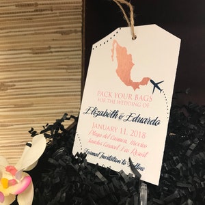 May include: A white luggage tag with a rose gold outline of Mexico and a small airplane. The text reads "Pack your bags for the wedding of Elizabeth & Eduardo January 11, 2018 Playa del Carmen, Mexico Sandos Caracol Eco Resort Formal Invitation to Follow"