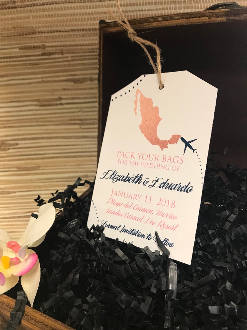May include: A white luggage tag with a rose gold outline of Mexico and a small airplane. The text reads "Pack your bags for the wedding of Elizabeth & Eduardo January 11, 2018 Playa del Carmen, Mexico Sandos Caracol Eco Resort Formal Invitation to Follow"
