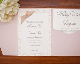 May include: A white wedding invitation with a pink envelope. The invitation features a lace-like border and a ribbon. The text on the invitation reads "Mr. and Mrs. Jack Brown request the honor of your presence at the marriage of their daughter Courtney Anne to Dustin Finch Saturday, the seventeenth of June, two thousand seventeen at five o'clock in the evening The Ritz-Carlton, Lake Tahoe 1385 Ritz-Carlton Highlands Court, Truckee, California Cocktail, dinner, and dancing to follow Black Tie Affair"