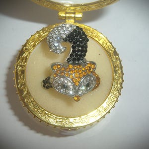 May include: A white ceramic mug with a black handle and the text "But First, Coffee" in a black, bold font. The mug is on a white surface.