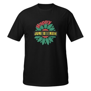 May include: Black t-shirt with a green and red flower graphic and the text "Happy Juneteenth" in yellow.