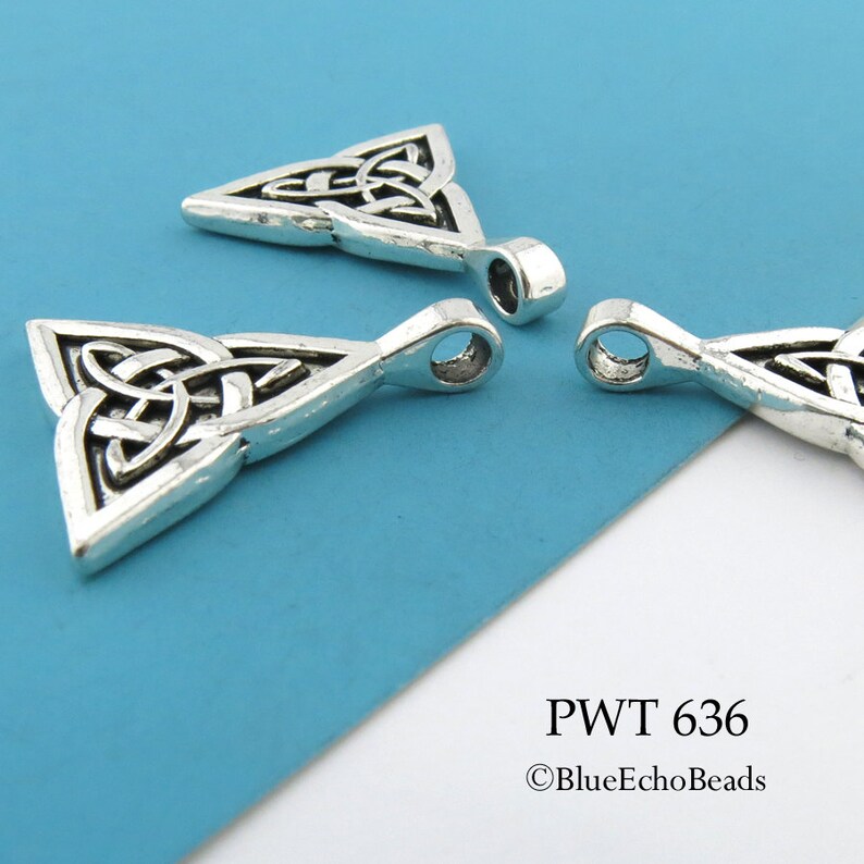 May include: Three silver Celtic knot triangle pendants with a loop at the top for hanging. The pendants are on a blue background. PWT 636 &copy;BlueEchoBeads